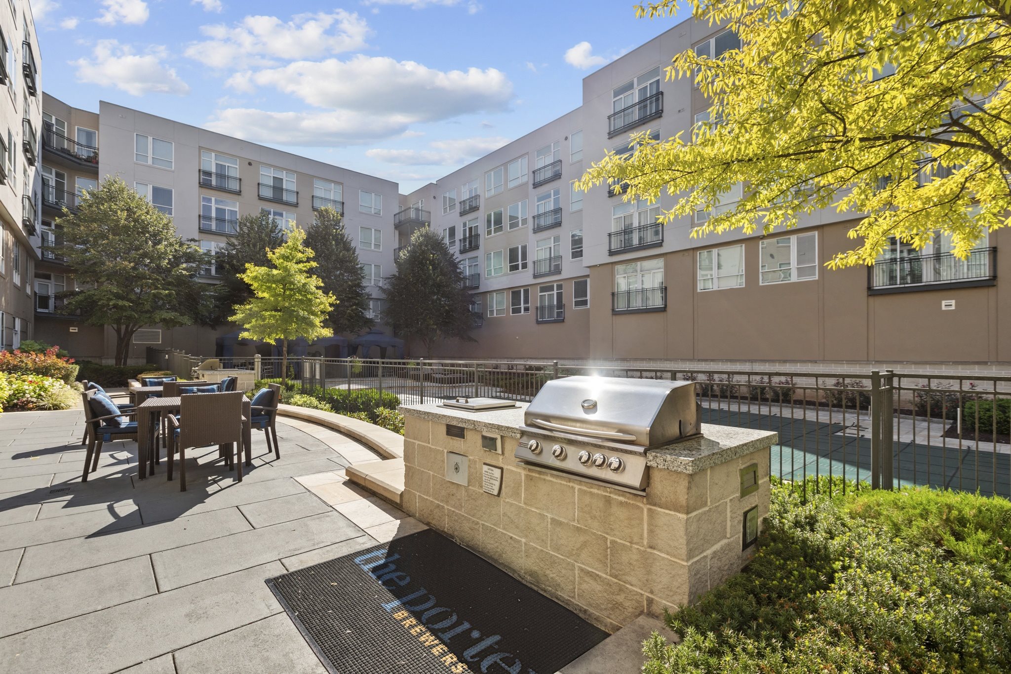 an outdoor patio with a grill and a table with chairs